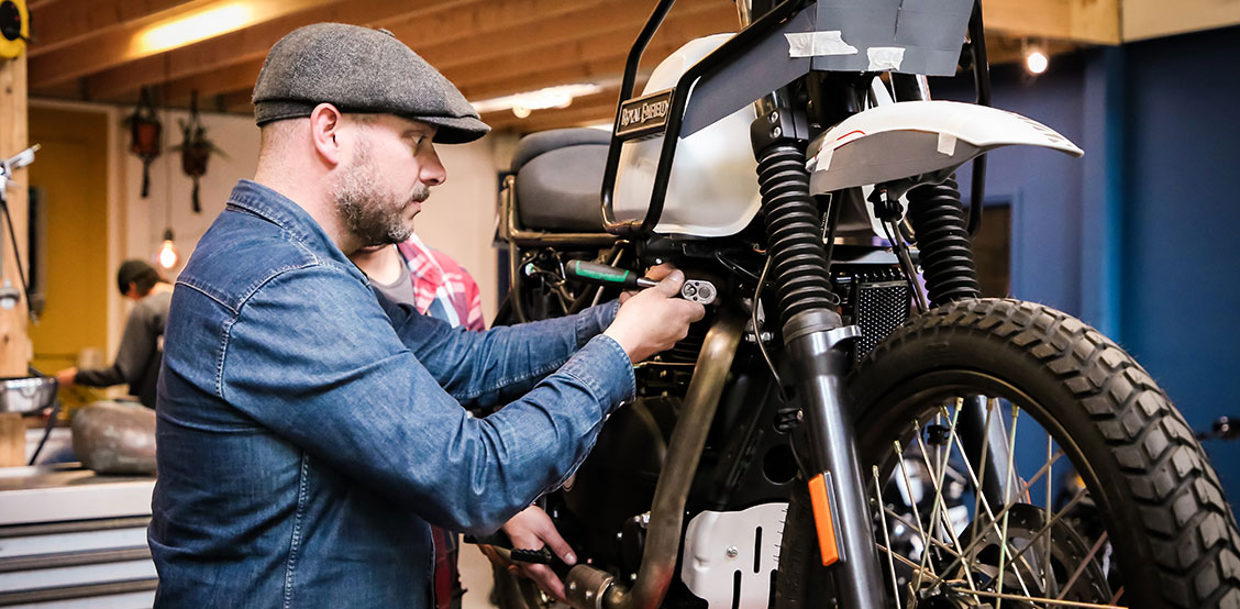 Man screws on a motorbike with STAHLWILLE tools