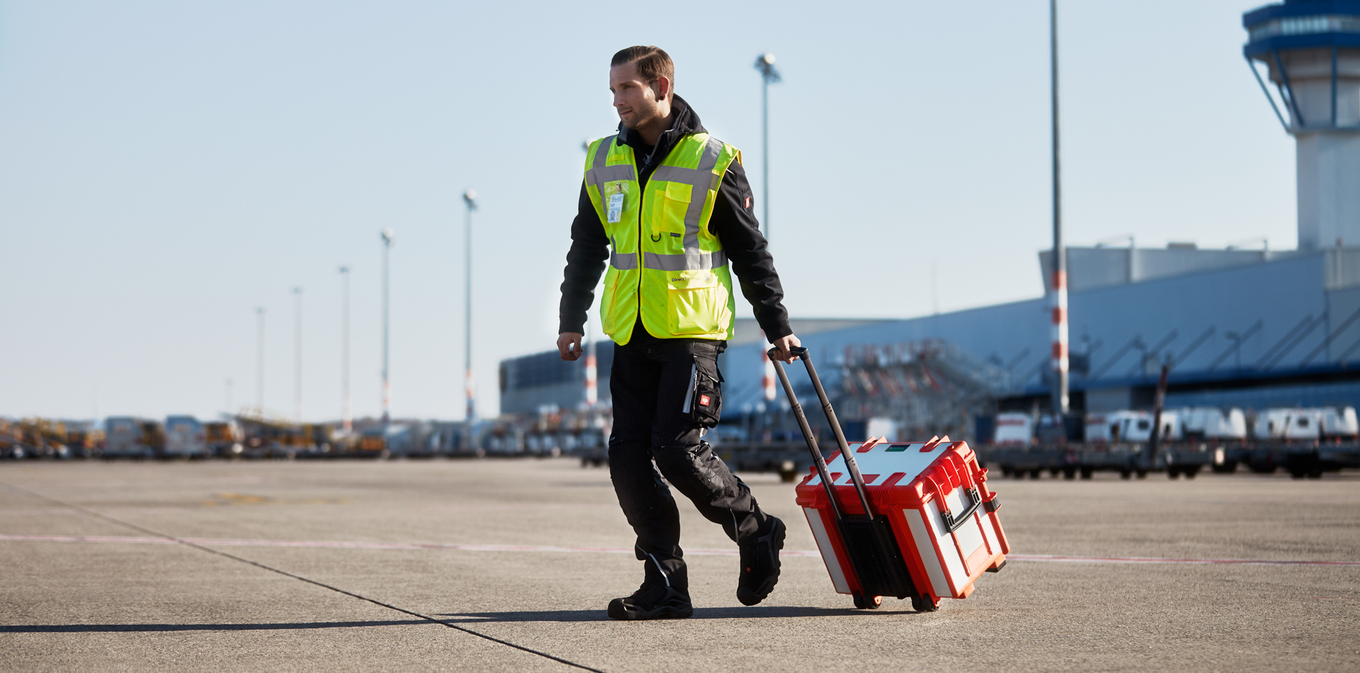 Operario transportando un maletín de herramientas móvil STAHLWILLE por un aeródromo